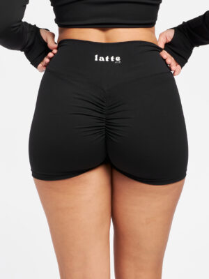 Vista de cerca del fruncido trasero del short Flat White negro