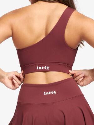 Primer plano del logo LatteFit en la espalda del top y la falda del set Red Vanilla.