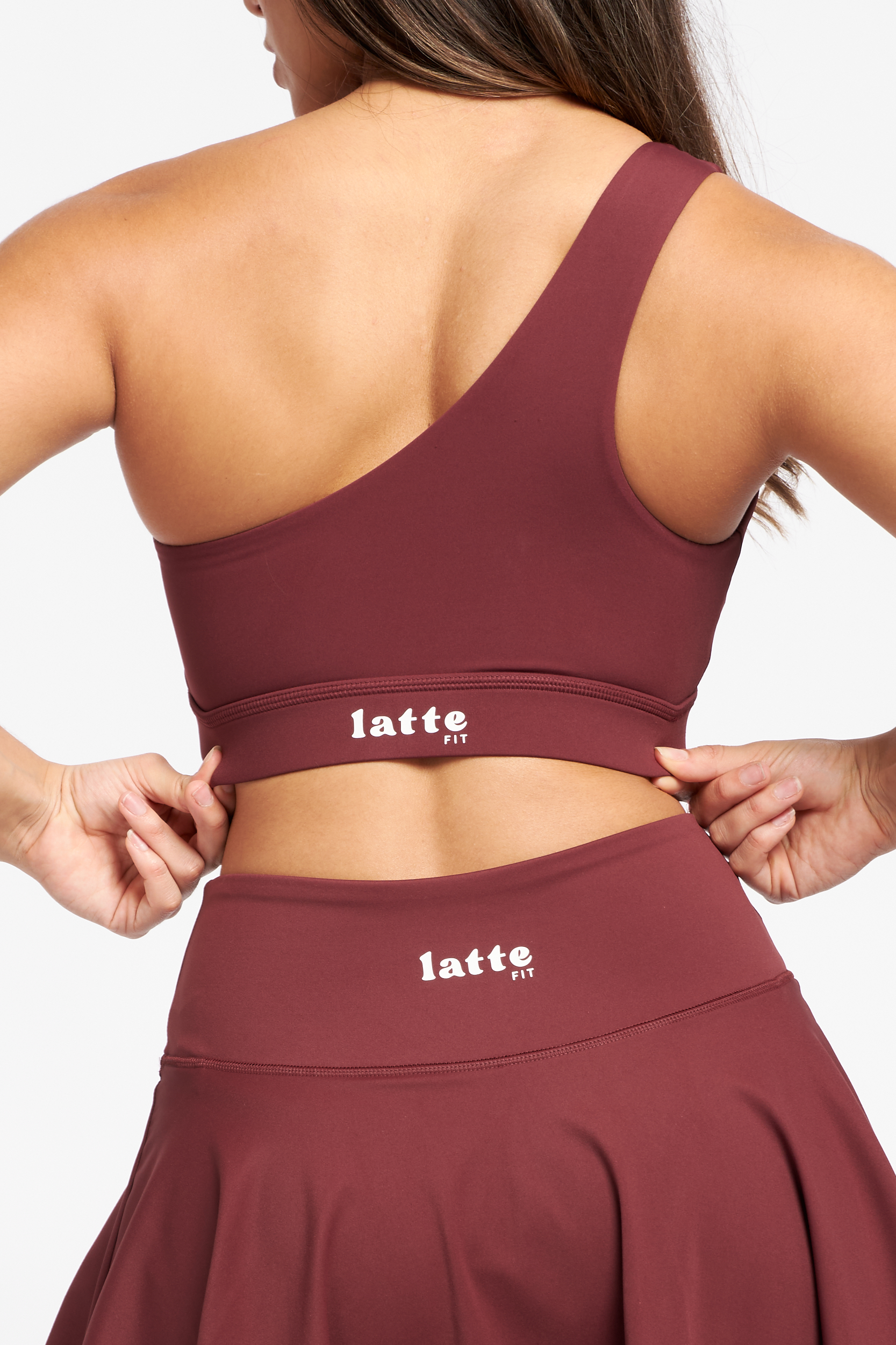 Primer plano del logo LatteFit en la espalda del top y la falda del set Red Vanilla.